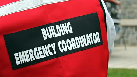 Close-up of the back of a red vest. It reads: Building Emergency Coordinator